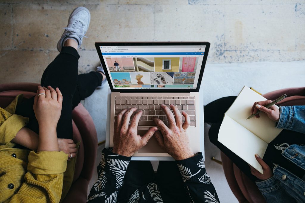 Photo taken from above, showing three people planning over a laptop