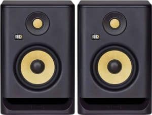 Displayed are a pair of black KRK studio monitors distinguished by their striking yellow woofers. Each monitor includes a tweeter situated above the woofer. The speaker cabinets exhibit a rectangular design with subtly rounded edges, complemented by a front-facing bass port positioned at the bottom.